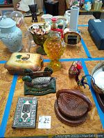 Overview of vintage decorative items including ceramics, glassware, bottle, and prayer book