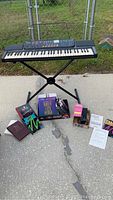 Full setup photo showing Casio keyboard on stand, music books, power cord, and music holder.