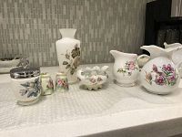 Lot of 2 teapots, vase, salt and pepper shakers, sugar container and small floral tray all on countertop showing patterns and general condition.