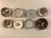 Top view of eight miniature decorative china plates with various floral, embossed, and patriotic designs.