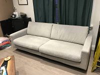 Front view of EQ3 OKSAR sofa showing two loose seat and back cushions on a light grey fabric frame