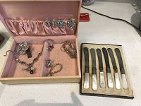 Overall view of the jewelry set and mother of pearl butter knives in original boxes.
