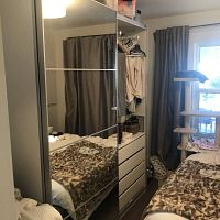 Front view showing full‐height mirrored sliding doors with divided rail design reflecting bedroom