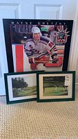 Photo showing Wayne Gretzky plaque in NY Rangers uniform and two framed golf prints in green frames on floor.