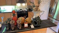 Countertop display showing all items including clock, clay pots, fruits, and figures.
