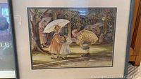 Framed print showing two girls with umbrella and clown figure, part of 3 print lot