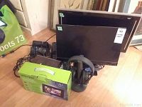 Photo showing the HP Pavilion 20 Bw 20 inch monitor, Centrios 20 inch LCD TV, Acer keyboard, Sony wireless headphones on stand, digital photo frame box, and cables.