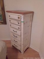 Front view of the off-white painted highboy dresser showing 7 drawers with metal pulls and natural wood top.