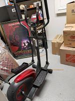 Elliptical machine from front angle showing frame, pedals, handles and console