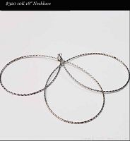 White gold necklace laid out on white background showing loops of chain and clasp.