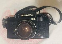 Front view of Miranda RE II camera with attached lens and shoulder strap visible.
