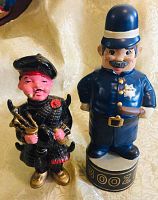 Front view of vintage ceramic liquor decanters of Scotsman and London Bobby policeman, showing detailed paint and features.
