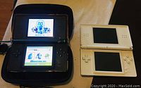Red DS Lite powered on and showing game screen next to white DS console powered off