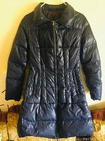Front view of the navy blue Kenzo puffer coat showing full length zipper and fitted waist