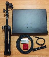 Photo of the Profile heavy duty music stand folded, with two patch cords, the Korg GA-30 tuner, Master Key chromatic pitch instrument box, and drum brushes arranged on floor.