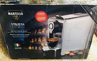 Box of Martello Stilista Primeo espresso machine showing espresso capsule system, Italian design, suitable for espresso and cafe lungo.