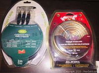 Photo of two packaged items: a roll of 12 gauge speaker wire labeled Genetic Energy Performance Speaker Wire, 50 ft and a blister pack with Prolink brand 2 meter component video RCA cable.