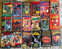 Front view of 20 superhero paperback comic books spread on a surface, including multiple Spider-Man issues, X-Men comics, Batman storylines, and a Superman book.