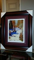Full front view of the professionally framed and matted art print titled 'Path Behind Mowat Lodge' by Tom Thomson, showing the dark wooden frame with corner protectors.