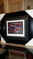 Full view of professionally framed and matted print titled "Salmon Hunter" showing black frame with white matting and vibrant multi-color abstract salmon artwork.