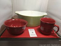 Photo showing the Corningware mixing bowl, red ceramic bowl, and red ceramic mug on a red placemat.
