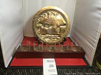 View of brass plate and candleholder base with 5 glass votive cups