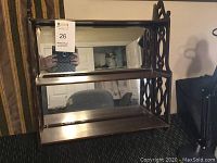 Front view of the vintage mahogany wall shelf showing three shelves and mirrored back.