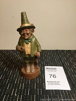 Front view of the Thomas F Clark Blarney figure with detailed facial features, green outfit, and walking cane, standing on a brown round base.