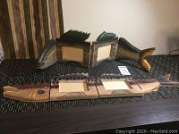 Two fish-shaped wooden picture frames placed on a surface, showing front and side angles.