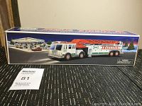 Photo of the Hess Fire Truck toy in original unopened box showing front and side of packaging with product illustration and features.