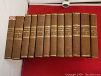 Twelve brown hardcover books lined up showing spine labels 'Schiller's Werke' volumes 1-12.