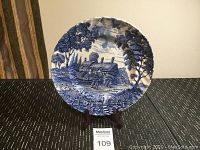 Front view of the Royal Essex decorative plate on stand showing the full image of the cottage scene with trees and figures.