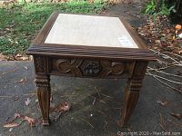 Side angle view showing carvings on legs and drawer pull