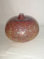 Front angle view of the round art glass lamp/vase showing iridescent speckled pattern and shape.