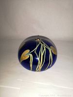 Front view showing iridescent dark blue glass with two heart shapes and linear decorative elements.