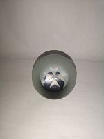 Top view showing white Maltese cross design inside clear frosted glass paperweight.