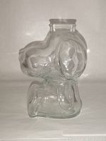 Side angle showing clear glass Snoopy bank with detailed head and ears.
