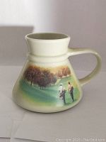 Photo of golf-themed Otagiri travel mug showing painted golf scene with two golfers on a hill with trees.