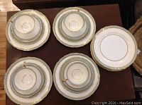 Top-down view of the cups nested on their saucers and stacks of the plates showing the set contents and design