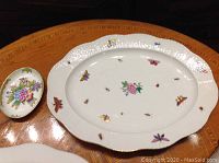 Full view of both Herend Queen Victoria porcelain pieces: 14 inch platter and small dish on wooden table