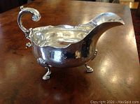 Front three-quarter view showing overall shape, handle, spout and cabriole legs