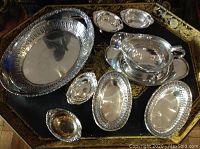 Complete pewter tea set including teapot, sugar bowl, creamer, and tray on a black velvet surface