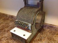 Front view showing embossed case, keys, white marble shelf