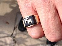Ring worn on finger outdoors showing size and top design