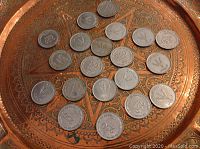 Overview of 19 Israeli 250 Prutah coins arranged on decorative tray