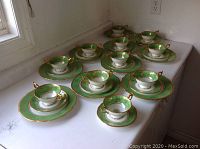Ten place settings arranged on flat surface showing bowls on saucers atop dinner plates