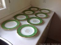 Eight Coalport dinner plates arranged on countertop