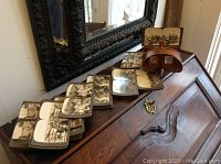 Wooden stereoscopic viewer and spread of stereoview cards on a wooden desk