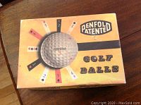 Original box of Penfold patented golf balls with graphic of golf ball and playing card suits.
