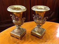 Front view of both bronze urns on wooden table